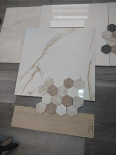 several different types of tile laying on top of a wooden floor next to each other