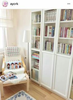 a chair in front of a book shelf filled with books