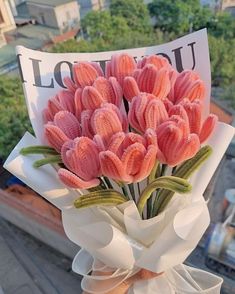 a bouquet of pink flowers sitting on top of a white ribbon