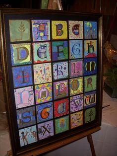 an art project is displayed on a easel with letters and numbers painted on it