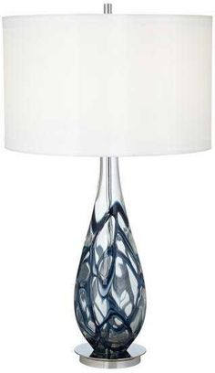 a glass table lamp with a white shade on the base and a silver metal base