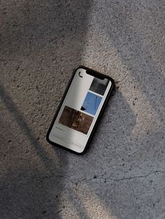 a cell phone laying on the ground with its cover open and it's screen showing images