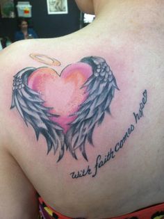 the back of a woman's shoulder with an angel and heart tattoo