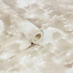 a roll of white paper sitting on top of a cloud filled floor covered in clouds