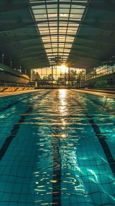 an empty swimming pool with the sun shining through the roof and reflecting on the water