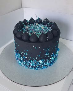 a blue and black cake with sprinkles on it