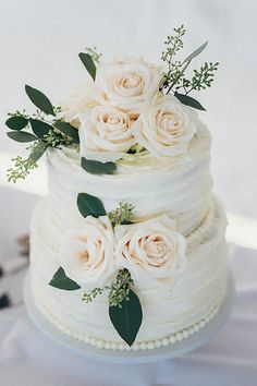 a wedding cake with white flowers and greenery