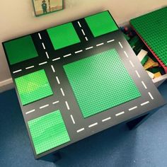 a table made out of legos with green and black squares