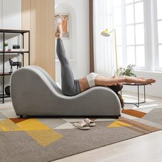 a woman laying on top of a couch in a living room