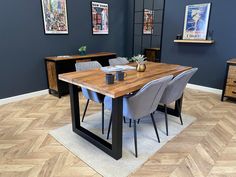 a dining room table with chairs and pictures on the wall behind it in an office setting