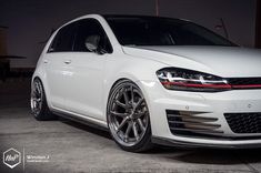 the front end of a white car parked in a garage