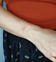 a woman's arm with a small star tattoo on the left side of her arm