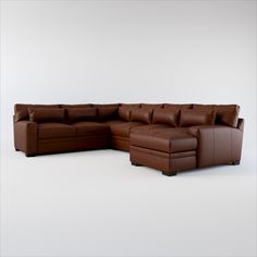 a large brown leather sectional sofa sitting on top of a white floor next to a footstool