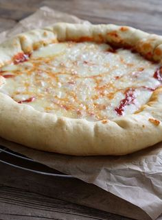 a pizza sitting on top of a wooden table