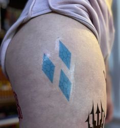 the back of a person's leg with blue and white designs on it,