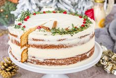 a cake with white frosting and red berries on top is sitting on a plate