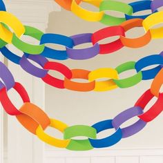 multicolored paper chain hanging from the ceiling in front of a white wall and door