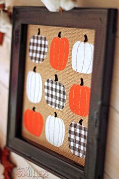 an orange and white pumpkin is mounted on a burlocked canvas in a black frame