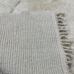 a white rug with fringes on top of it