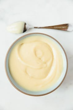 a bowl of cream next to a spoon