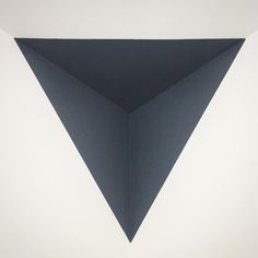 an abstract painting with black and white triangles on the wall in front of a window