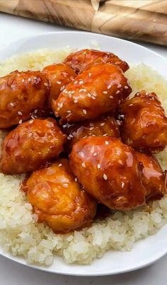 a white plate topped with rice covered in sauce and chicken wings on top of it