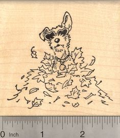 a wooden rubber stamp with a dog wearing sunglasses and falling leaves on it's face