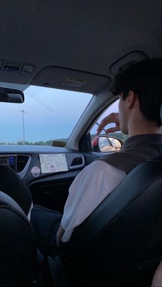 two people sitting in the back seat of a car looking at something on the screen