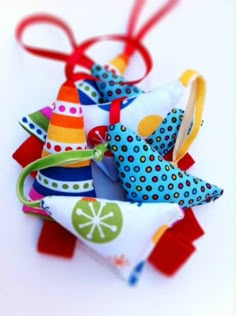 several colorful objects are sitting together on the table and tied to ribbons in different colors