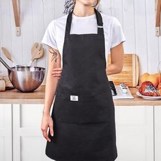 a woman in an apron standing next to a counter