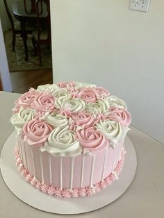 a pink and white cake sitting on top of a table