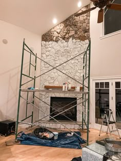 a living room with a fire place and scaffolding on the wall next to it