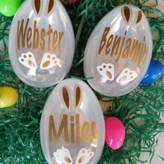 three plastic easter eggs decorated with bunny ears and the words webster belgium on them