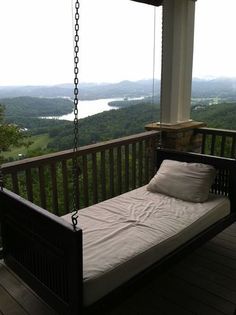 a swing bed on a porch with a view