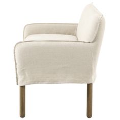 a white chair with wooden legs and a pillow on it