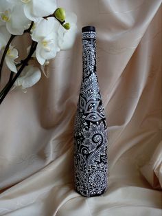 a black and white vase sitting on top of a table next to a bouquet of flowers