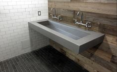 a bathroom sink sitting under a mirror next to a tiled wall and flooring on the walls