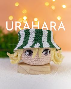 a crocheted doll wearing a green and white hat with the words urahara above it