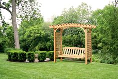 a wooden bench sitting in the middle of a lush green park