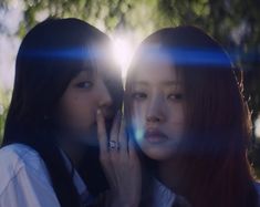 two young women standing next to each other with their hands on their faces and looking at the camera