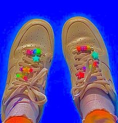 a pair of white sneakers with colorful stars on them