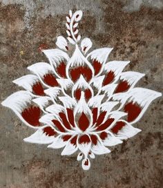 an intricately painted design on the side of a concrete wall in red and white