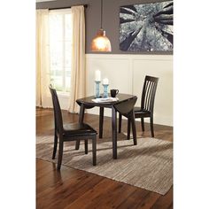 a dining room table with two chairs and a rug