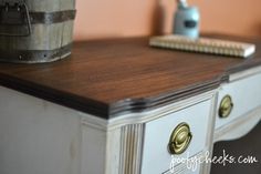 an old desk with some paint and a brush on it's top, next to a bucket