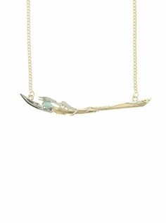 a gold necklace with an arrow and two small birds on the branch, hanging from a chain