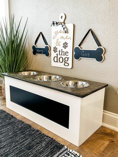 a white dog bed with two bowls on it and a sign that says the dog