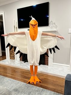 a person in a chicken costume standing with their arms spread out and feet stretched out