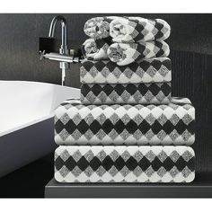 a stack of towels sitting on top of a sink next to a faucet