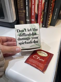 a hand is holding up a small card that says don't let the difficult - to damage your spiritful - tea