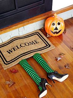 there is a welcome mat on the floor next to two shoes and a jack - o'- lantern